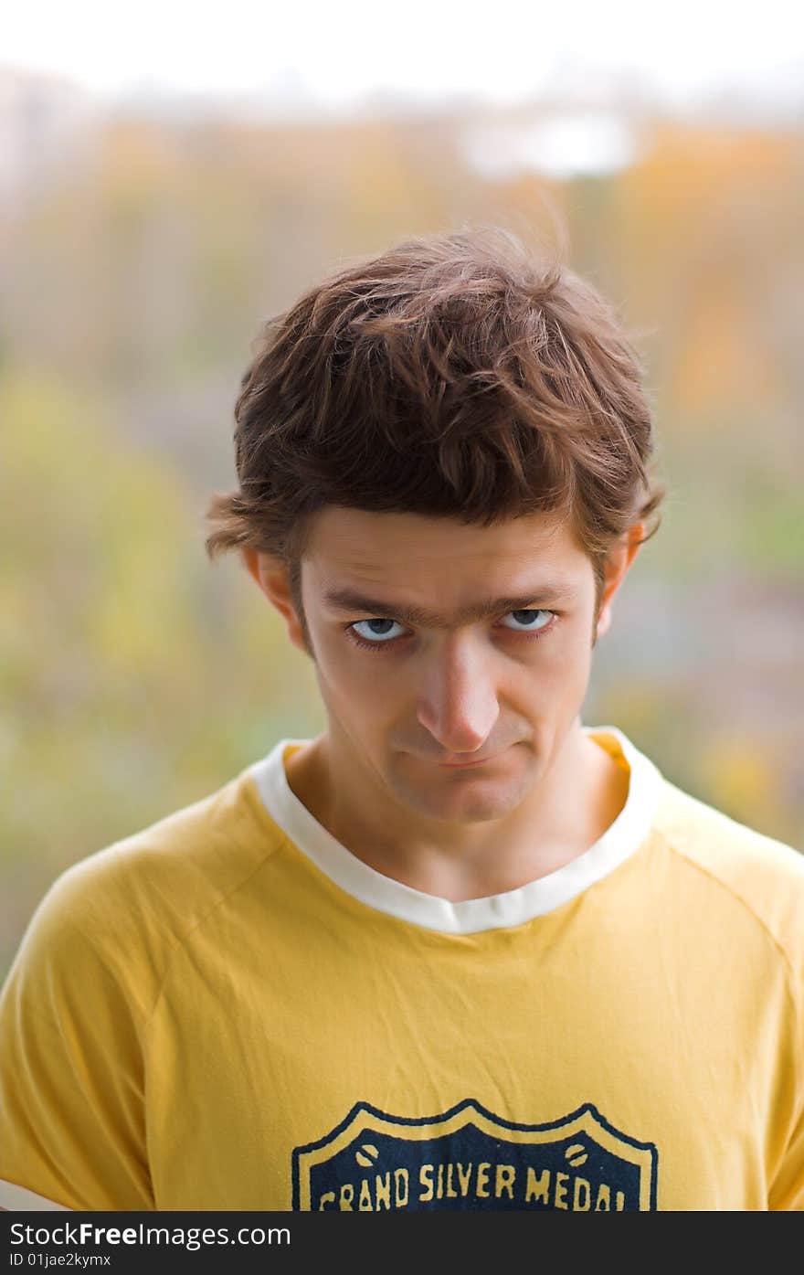 A stare of the young man in a yellow T-shirt.