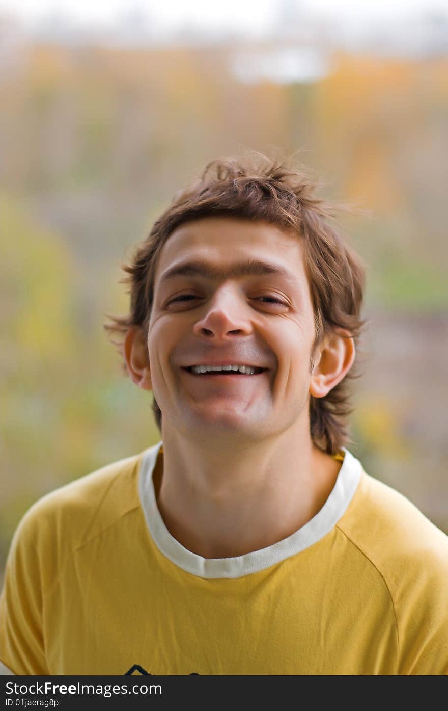 The laughing young man in a yellow T-shirt. The laughing young man in a yellow T-shirt.