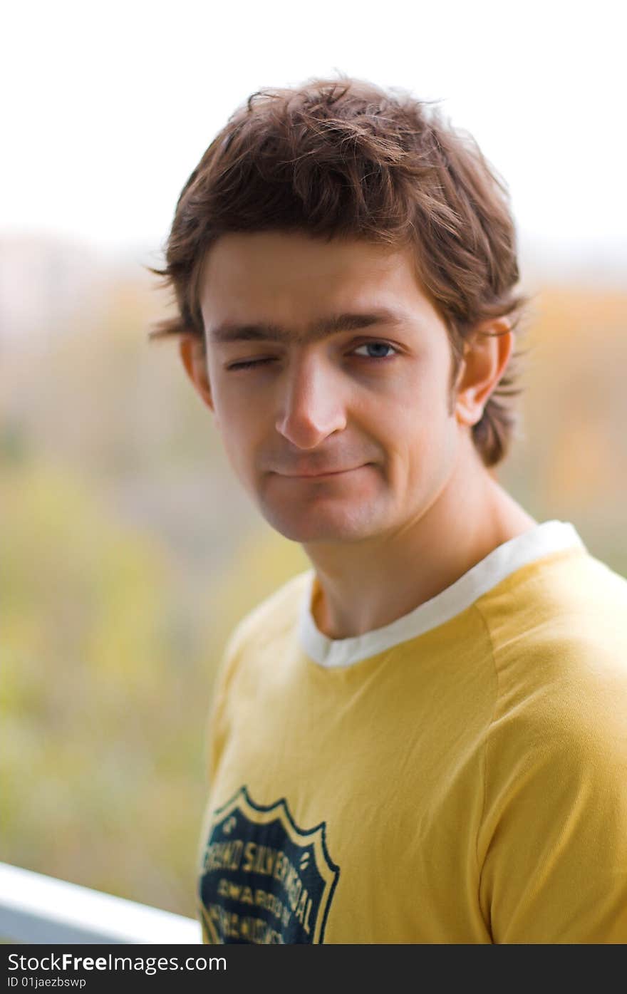 The winking young man in a yellow T-shirt.