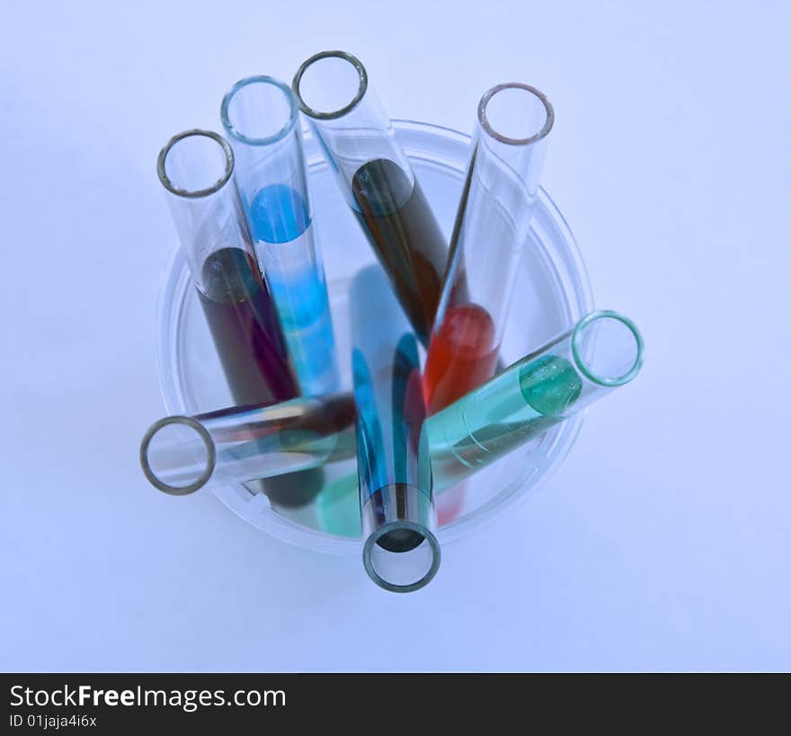 Upper view of some test tubes containing various solutions in a specific research laboratory lighting.