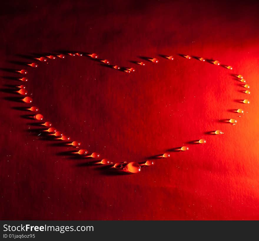 Water drops in the form of heart on a celebratory background