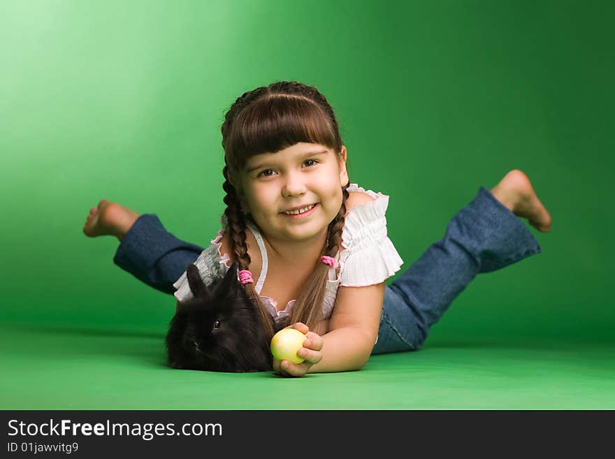 Girl with yellow easter eggs and a black rabbit