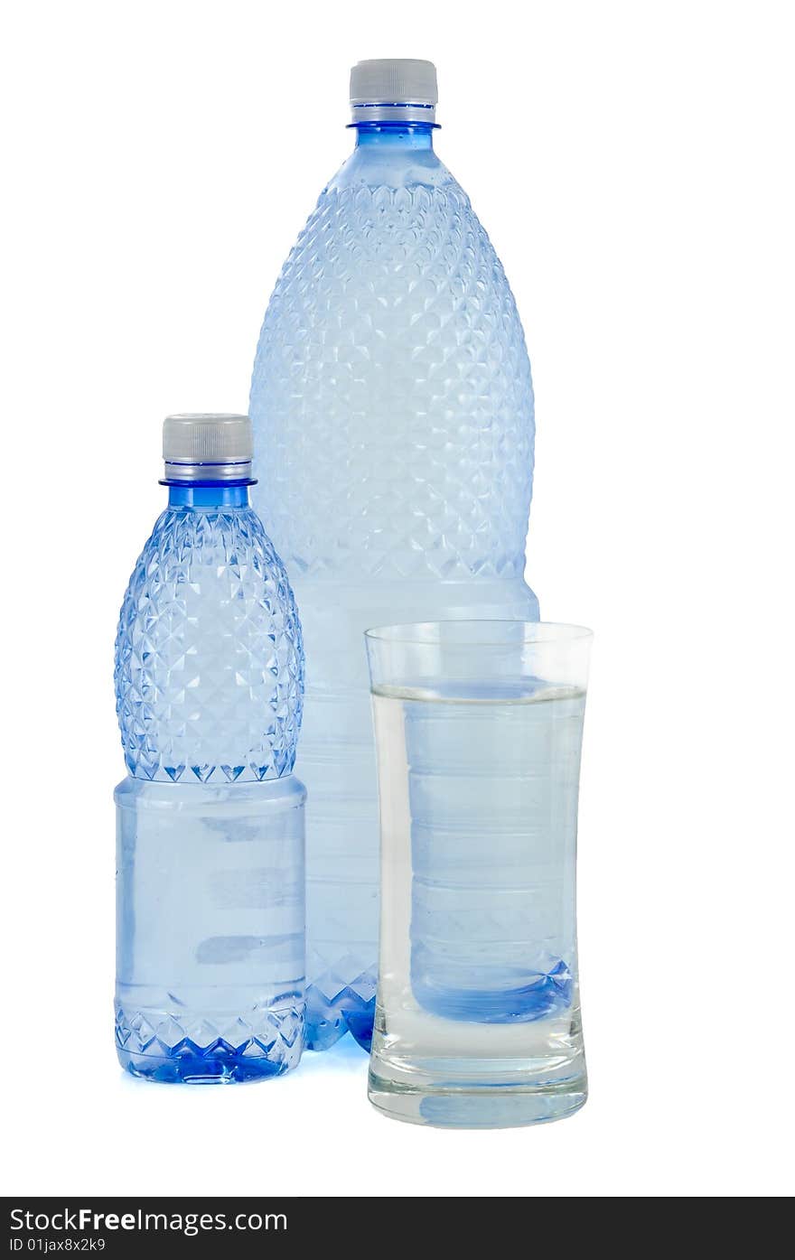 Glass and bottles of water on white background