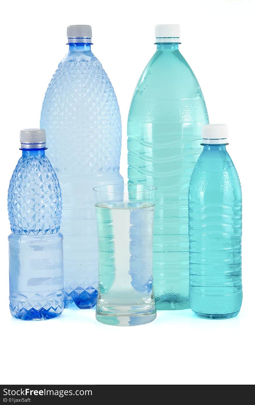 Glass and bottles of water on white background