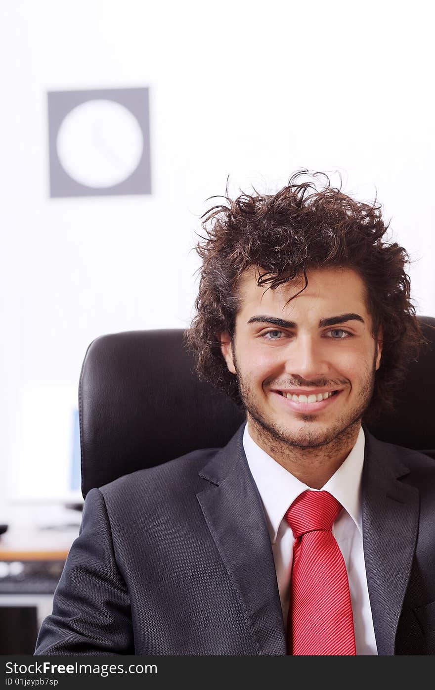 Businessman in the office, smiling and looking in camera