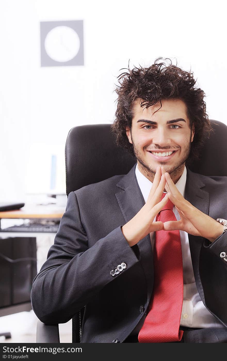 Businessman in the office, smiling and looking in camera