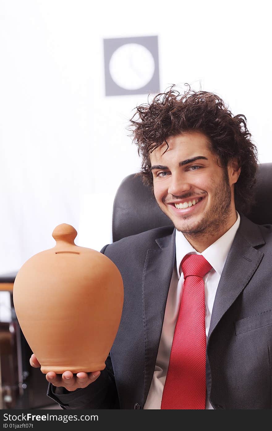 Businessman in the office with moneybox