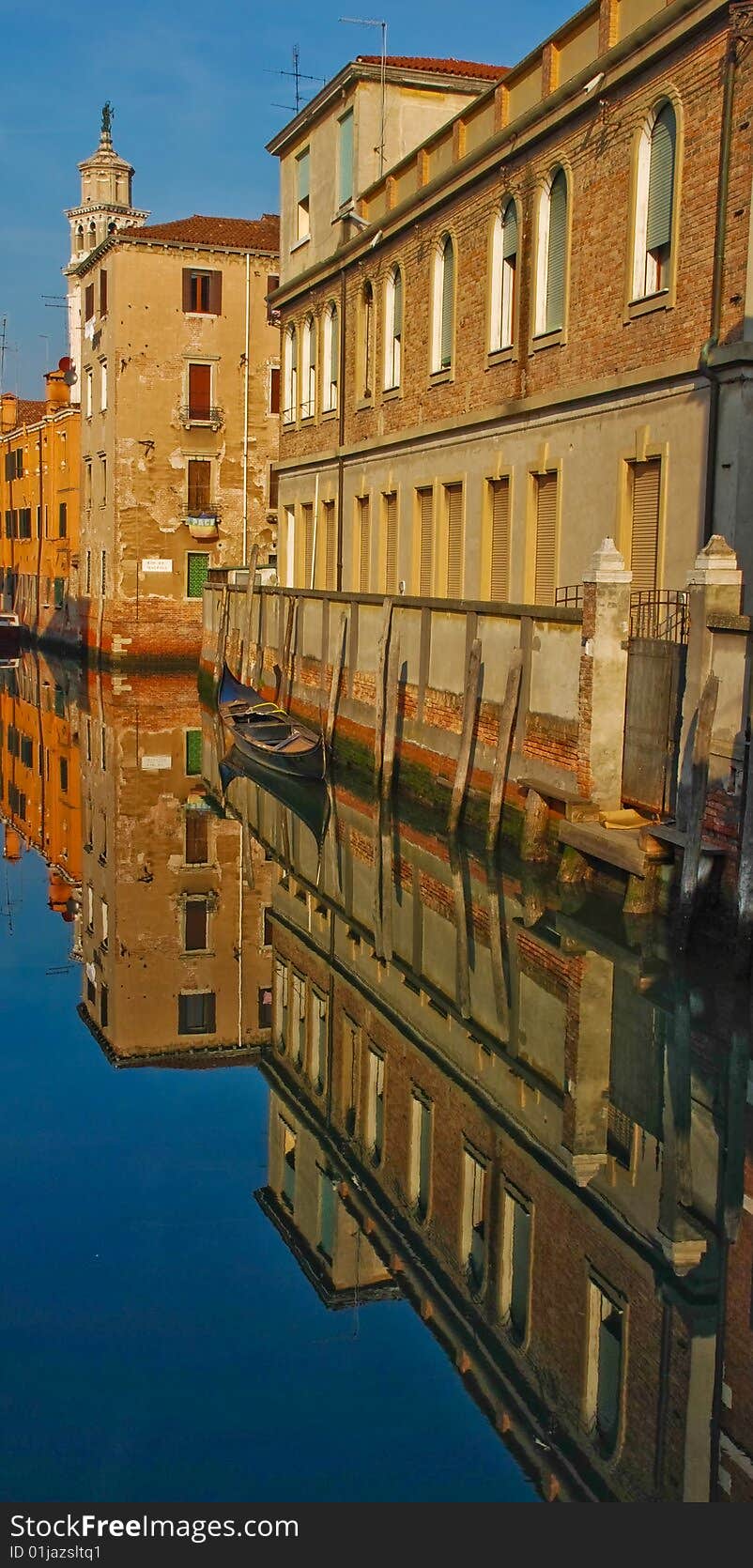 Old buildings are reflecting in waters of Venice canal