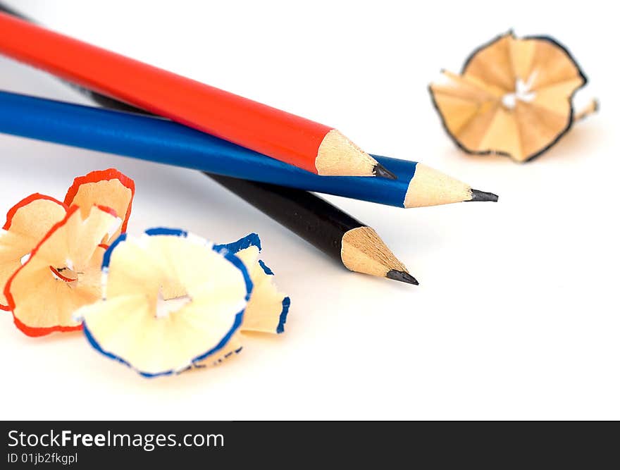 Three sharpened pencils and theirs shavings.