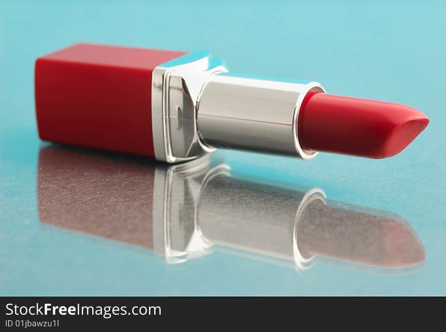 Red lipstick on blue mirror background. Red lipstick on blue mirror background