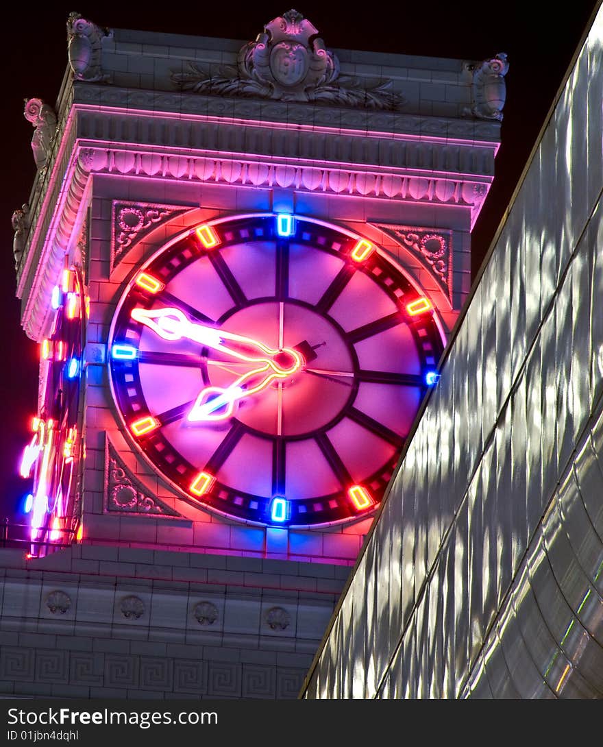 Neon clock atop an old building. Lots or architecural details - clamshells, scrolls, carving and tilework. Neon clock atop an old building. Lots or architecural details - clamshells, scrolls, carving and tilework.