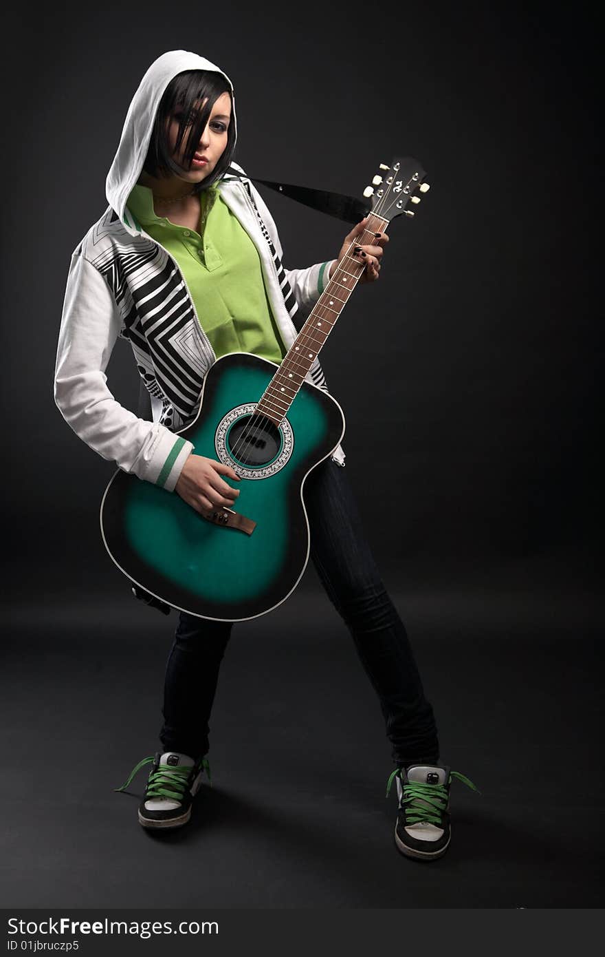 Emo girl with guitar on black background