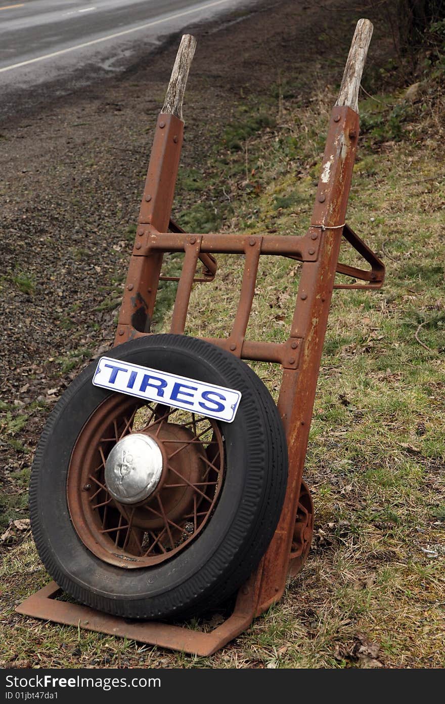 Tire sign on old antique hand truck advertising business. Tire sign on old antique hand truck advertising business