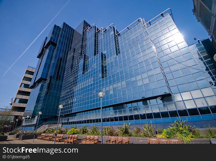 Shiny glass office building against blue sky