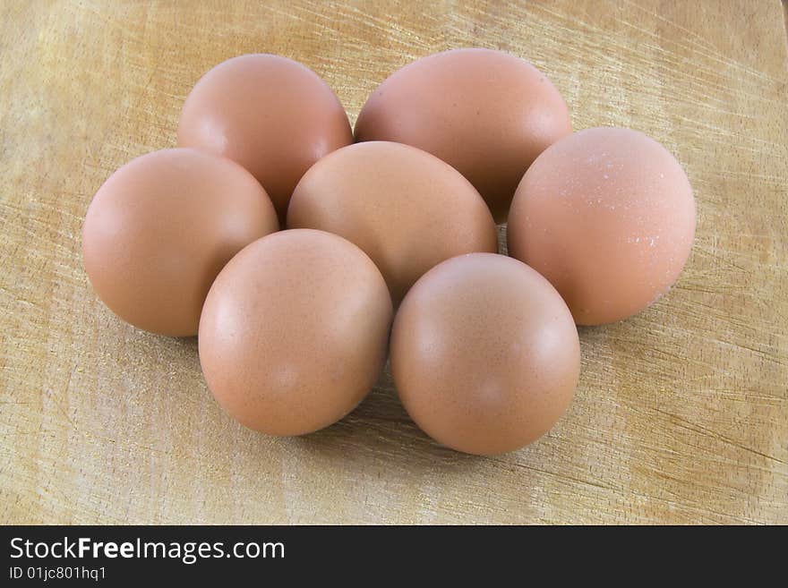 Many fresh rural eggs on the wooden surface