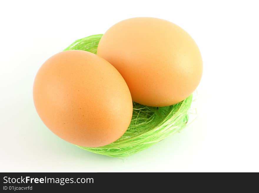 Two eggs in green nest over white background. Two eggs in green nest over white background