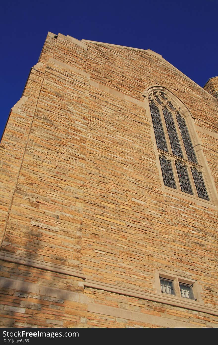 Church facade with stained glass windows and blue sky.