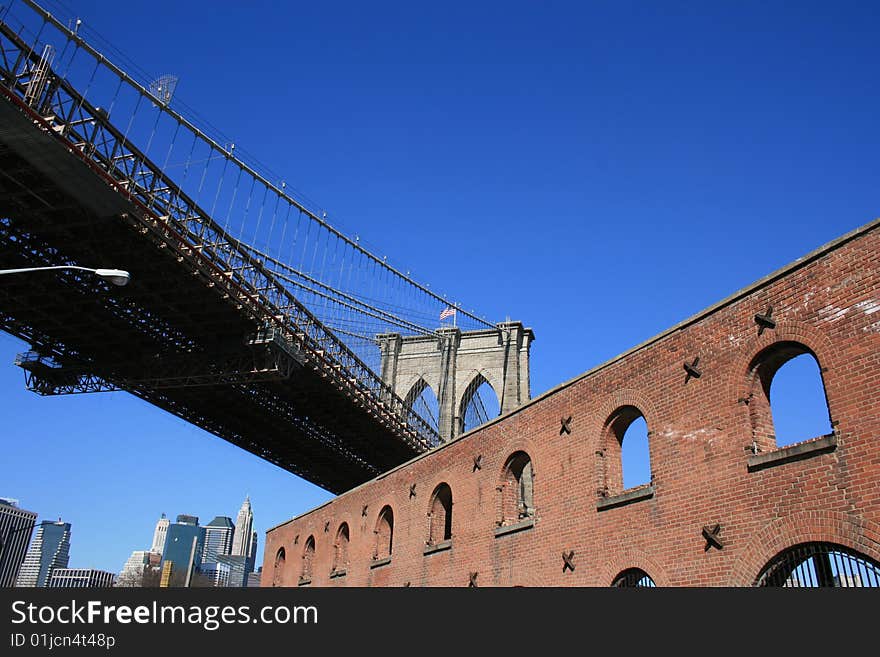 Brick building below the Brooklyn Bridge.  Lower Manhattan skyline in the background. Brick building below the Brooklyn Bridge.  Lower Manhattan skyline in the background.