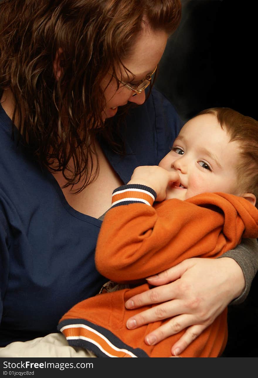 A mother wraps her arms around her boy in a loving gesture. A mother wraps her arms around her boy in a loving gesture.