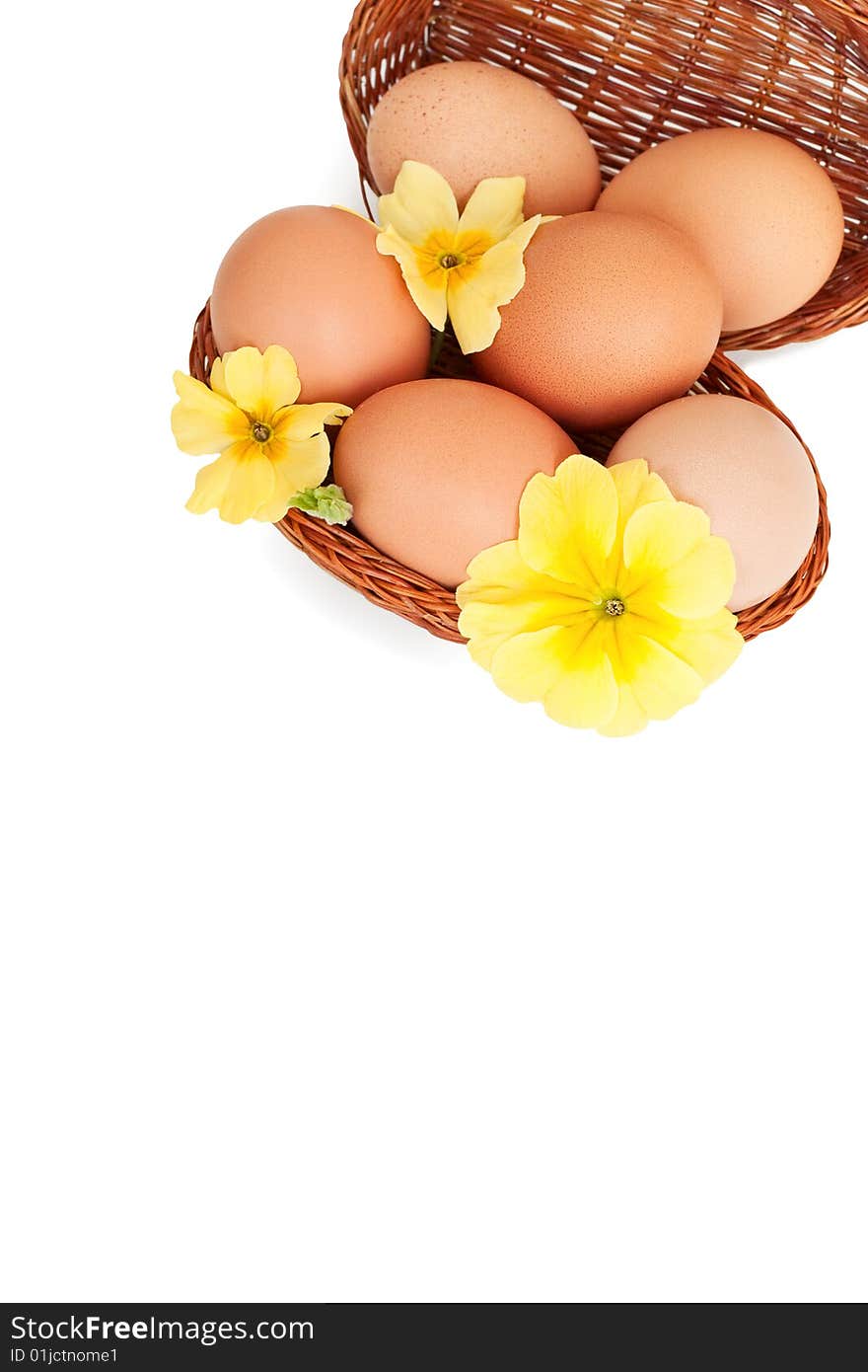 Eggs in baskets with spring flowers, isolated