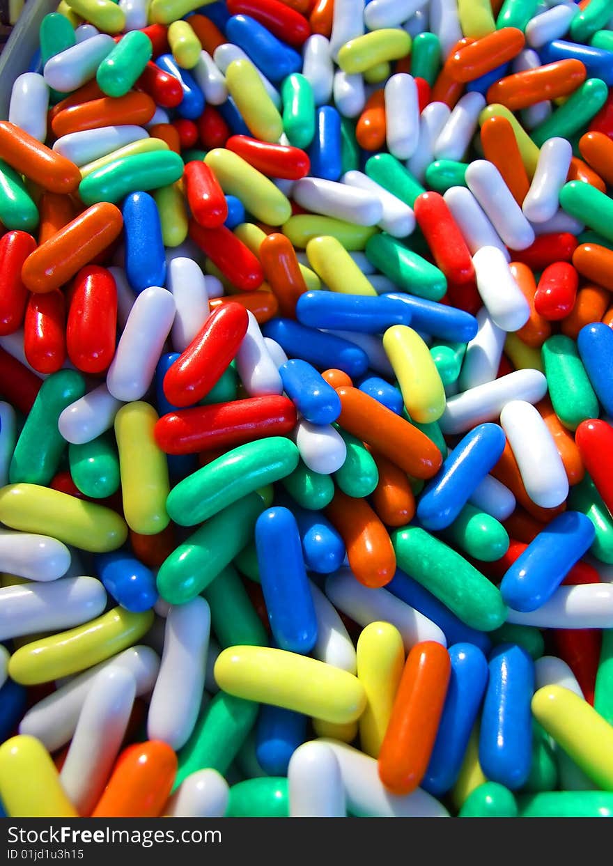 Pills or sweets in blue, white, red, yellow, orange and green