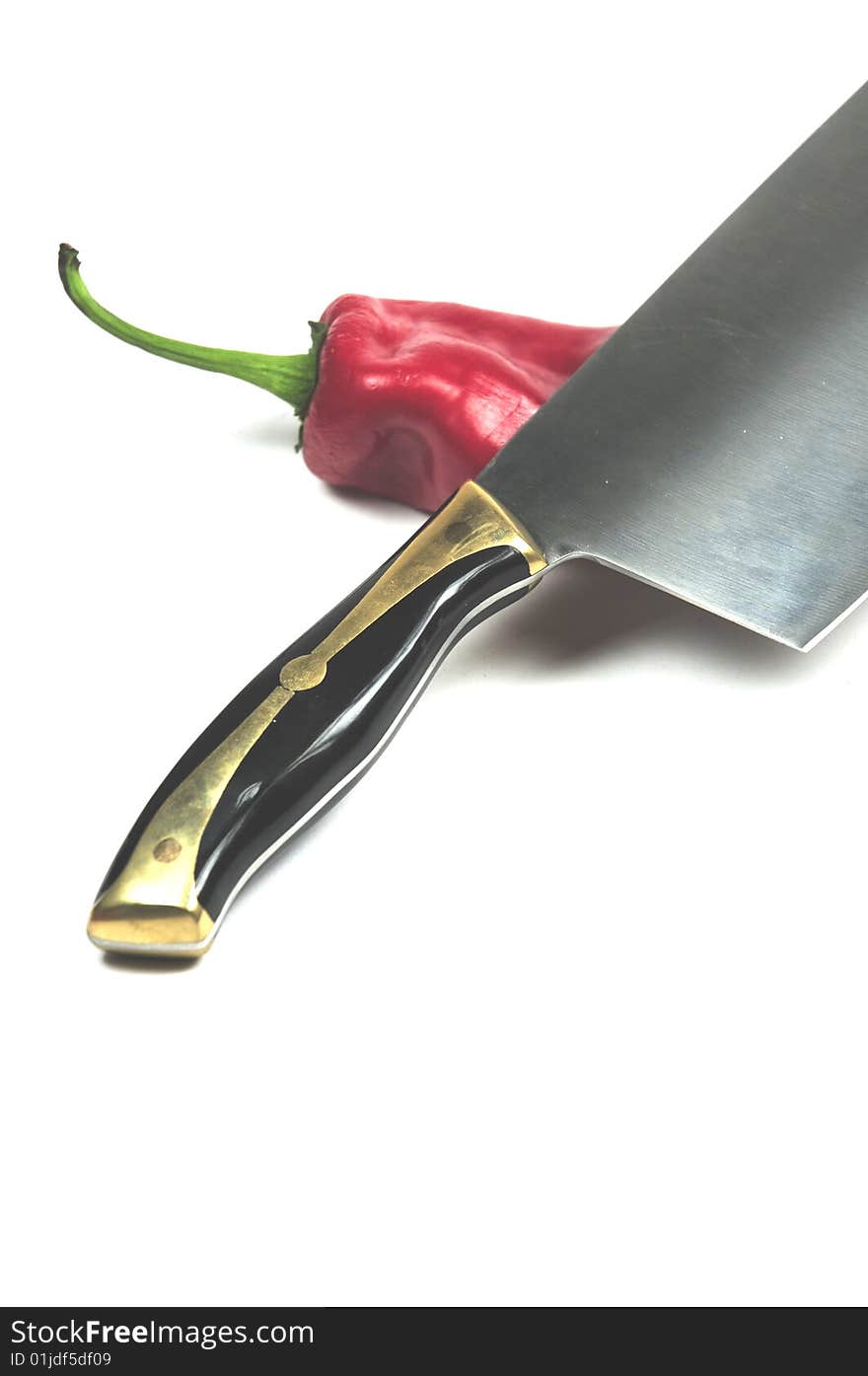 A Chinese cleaver an a red pepper. A Chinese cleaver an a red pepper