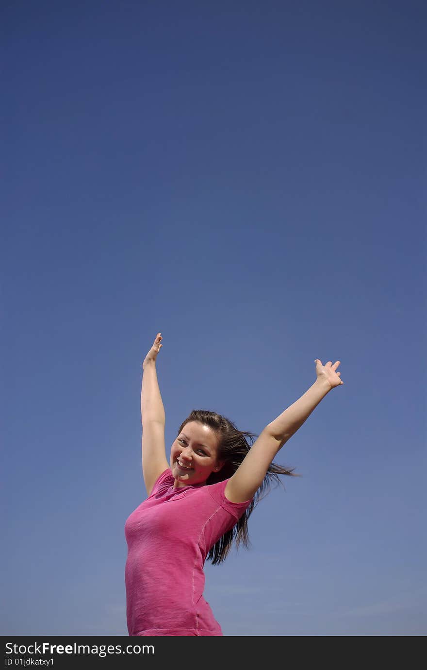 A teen girl celebrates a cloudless sky. A teen girl celebrates a cloudless sky.