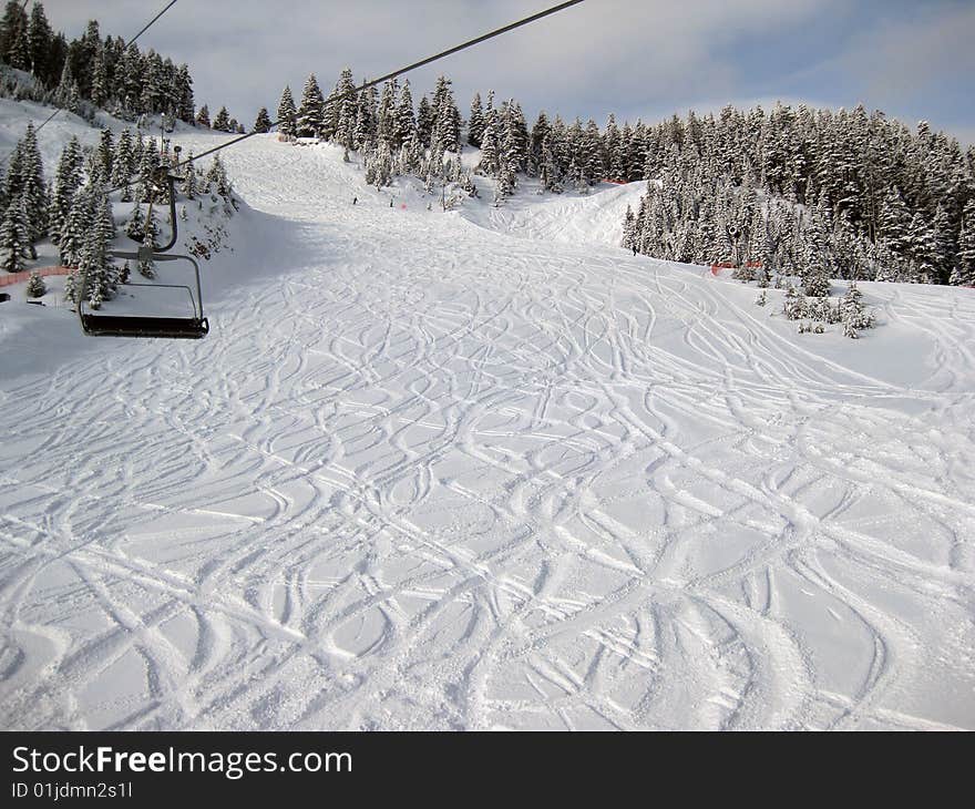 Ski lift an fresh skied snow in a sunny day. Ski lift an fresh skied snow in a sunny day