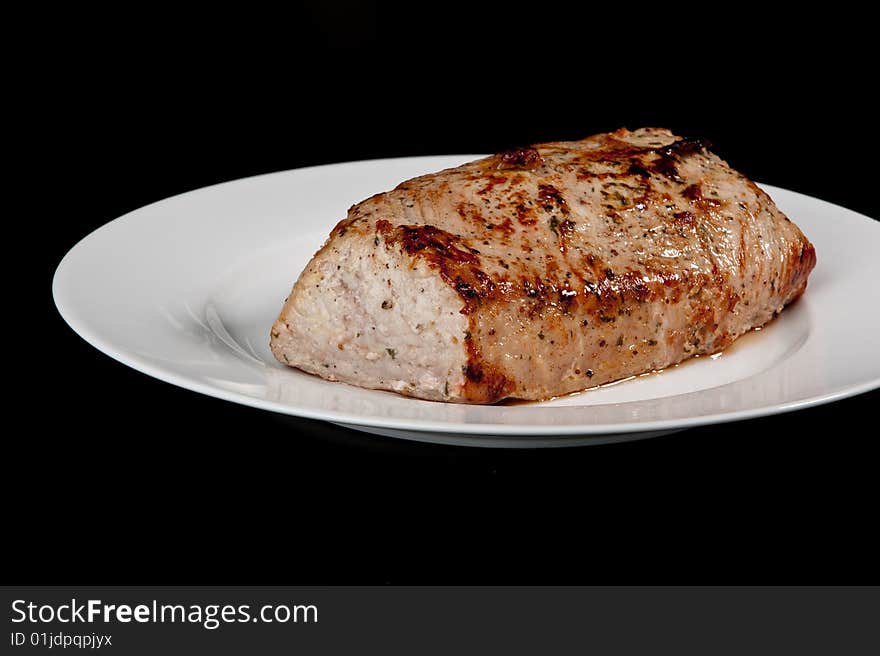 Image of a freshly cooked pork loin on a plate. Image of a freshly cooked pork loin on a plate