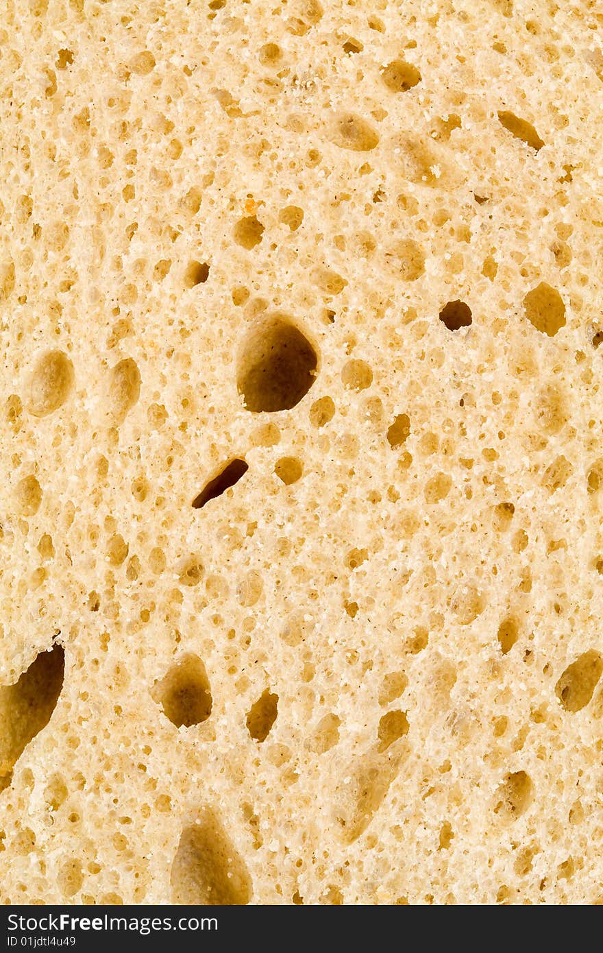 A close up of the texture of a slice of white bread. A close up of the texture of a slice of white bread