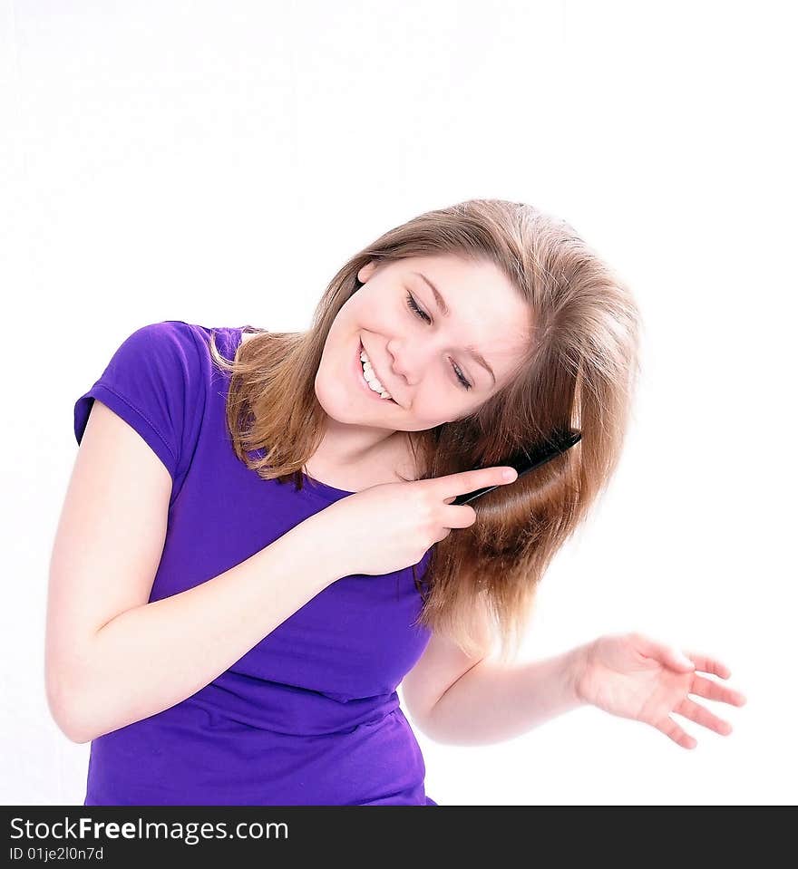 Studio Shot of a beautiful girl in a blue t-shirt dressing her hair, isolated on white background. Studio Shot of a beautiful girl in a blue t-shirt dressing her hair, isolated on white background