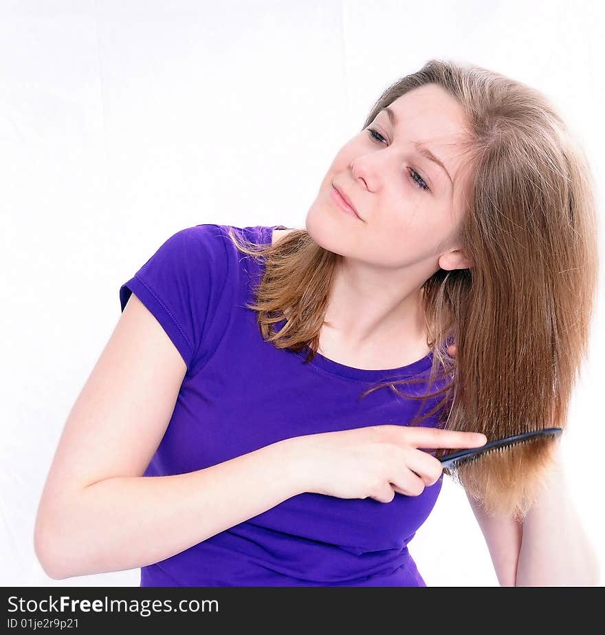 Studio Shot of a beautiful girl in a blue t-shirt dressing her hair, isolated on white background. Studio Shot of a beautiful girl in a blue t-shirt dressing her hair, isolated on white background