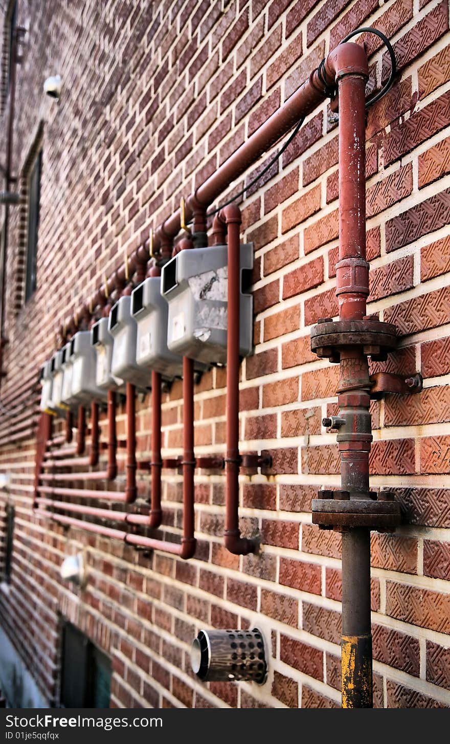 Gas Meters in Perspective hung on stark red brick wall in perspective