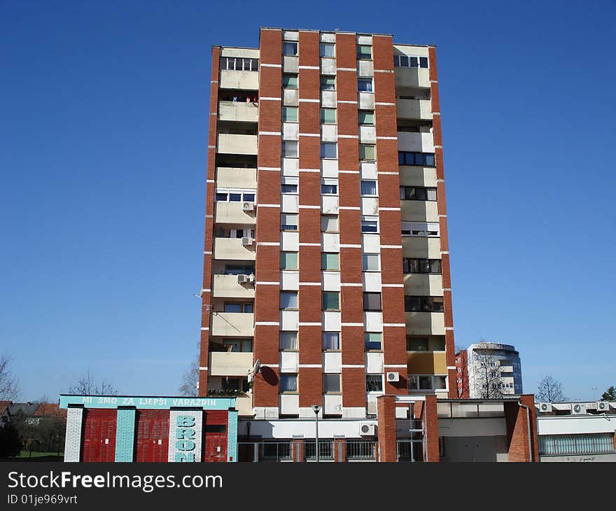 Older brick apartment building with white balconies.