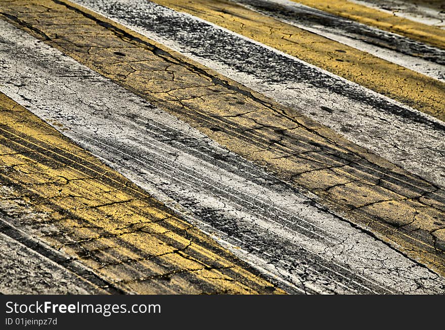 Cracked Yellow and White Paint on Black Asphalt Road