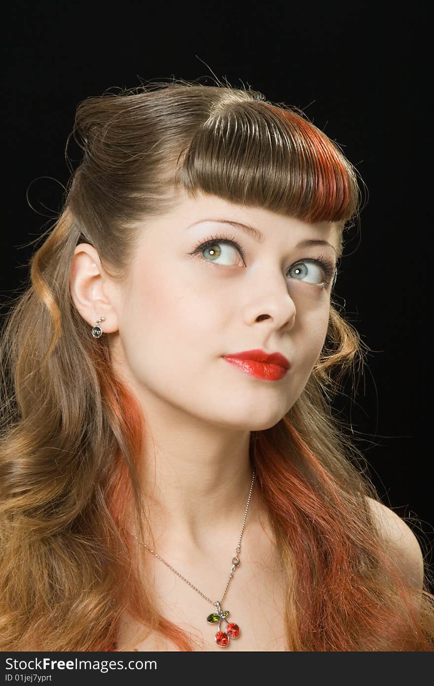 Pretty woman with light make-up looking pensively over dark background