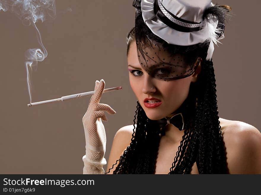 Fashionable retro girl smoking long cigarette. Fashionable retro girl smoking long cigarette