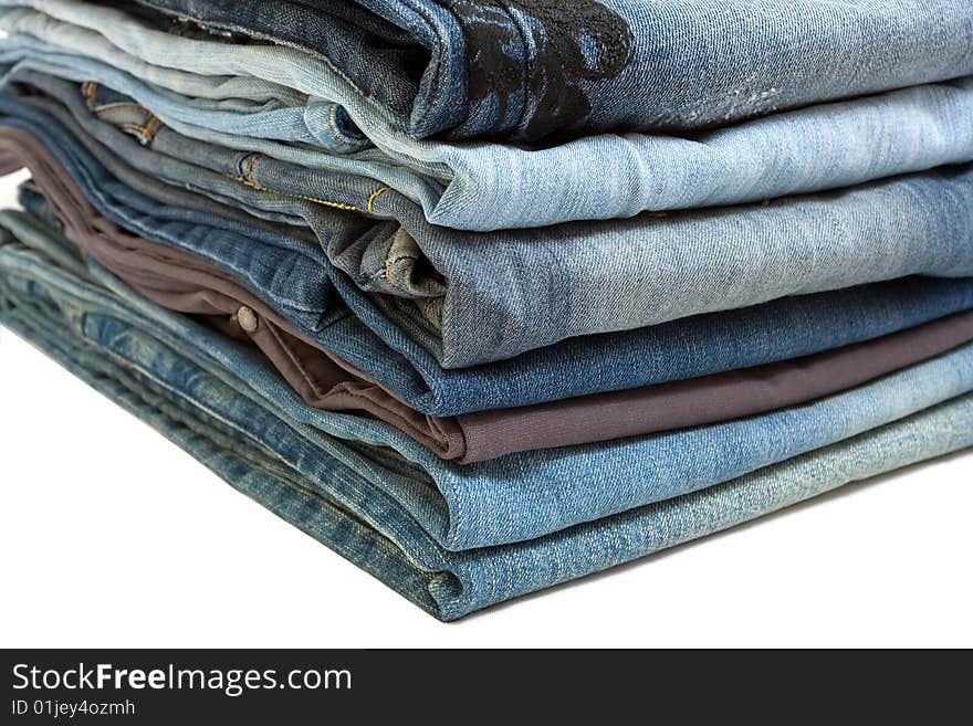 Stack of blue jeans on white