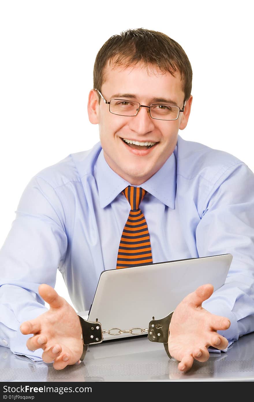 Handsome young businessman bound to laptop with handcuffs. Handsome young businessman bound to laptop with handcuffs