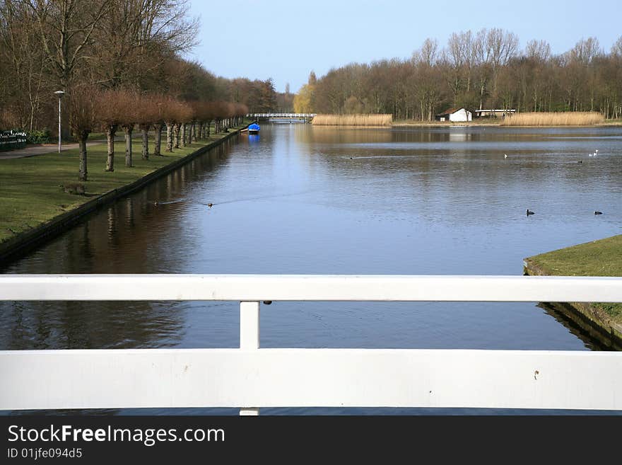 Public garden in The Hague by autumn. Netherlands. Pond and white bridge.