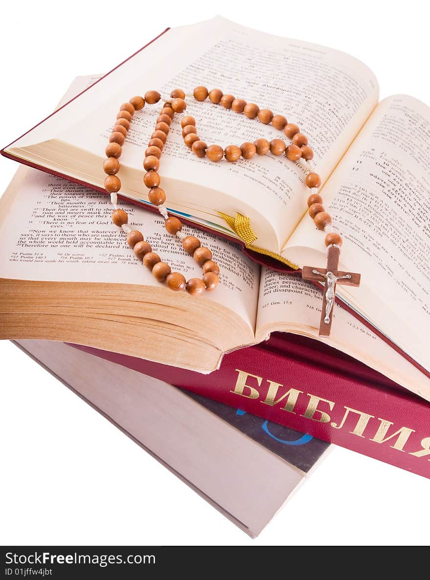 Open Holy Bible lying on stack of old books with glasses, cross and beads. Open Holy Bible lying on stack of old books with glasses, cross and beads