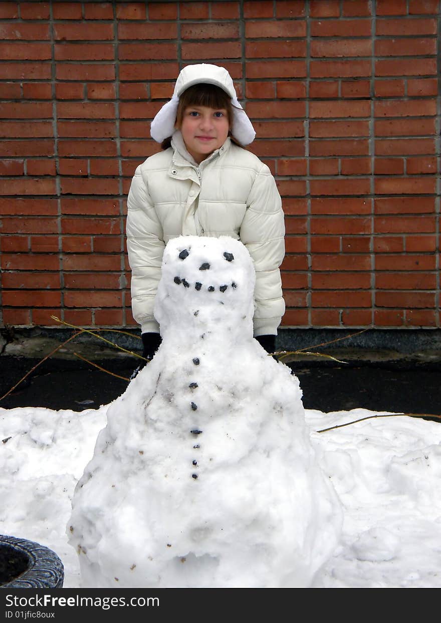 Smiling girl in white and snowman. Smiling girl in white and snowman