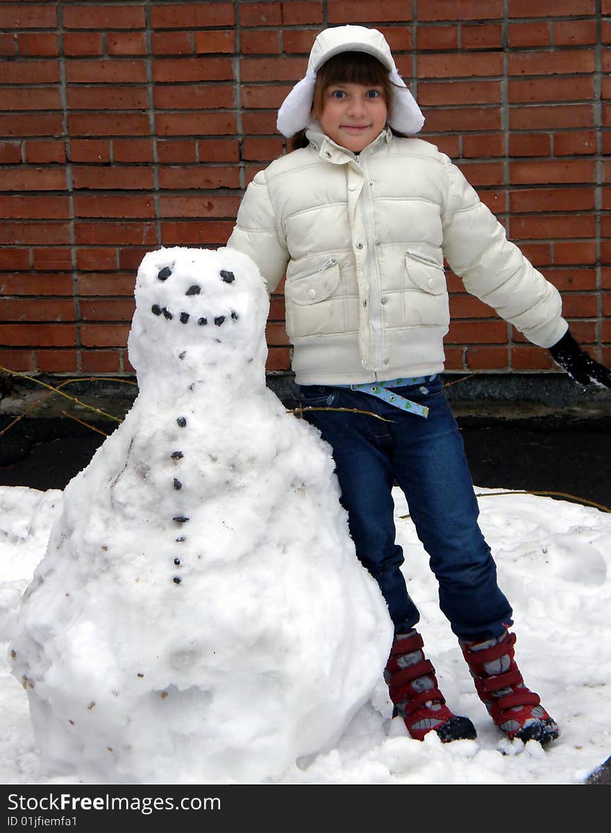 Smiling girl in white and snowman. Smiling girl in white and snowman