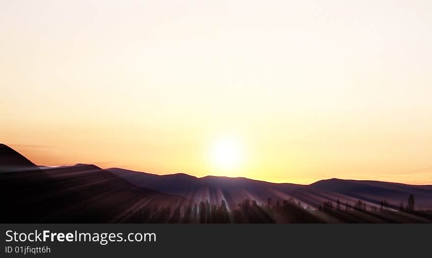 Sunset in the mountains with light sunbeams