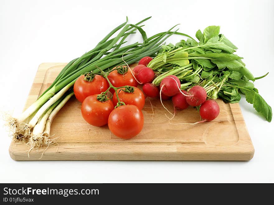 Fresh vegetables on chopping board against white background