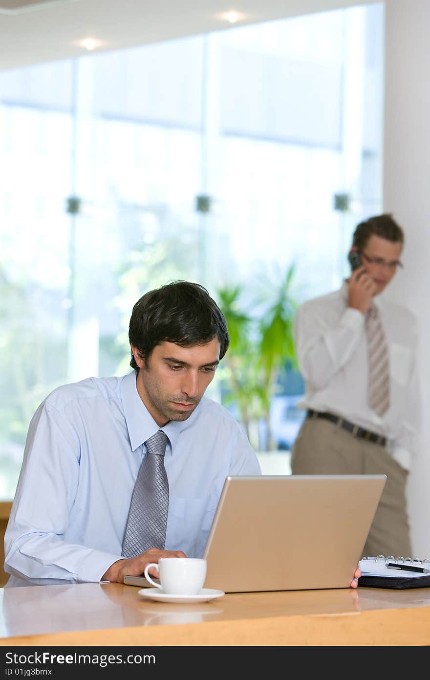 Confident young business man working on laptop.