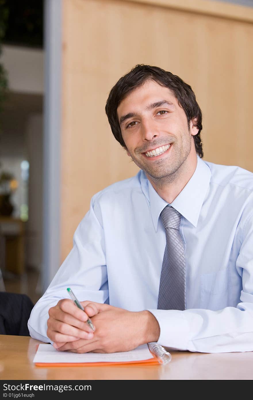 Portrait of smiling business man working by desk. Portrait of smiling business man working by desk.