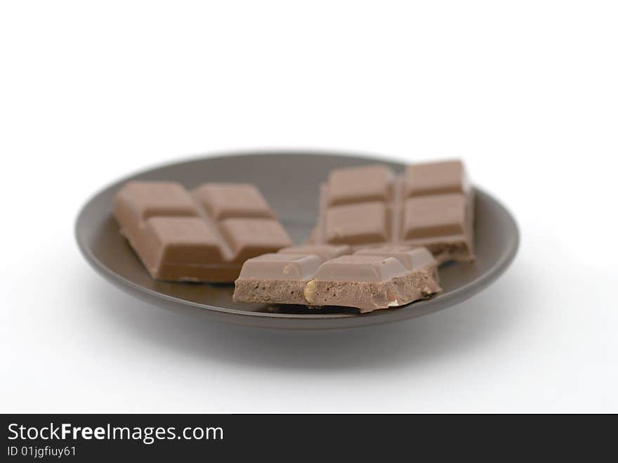 Dark chocolate pieces on brown saucer