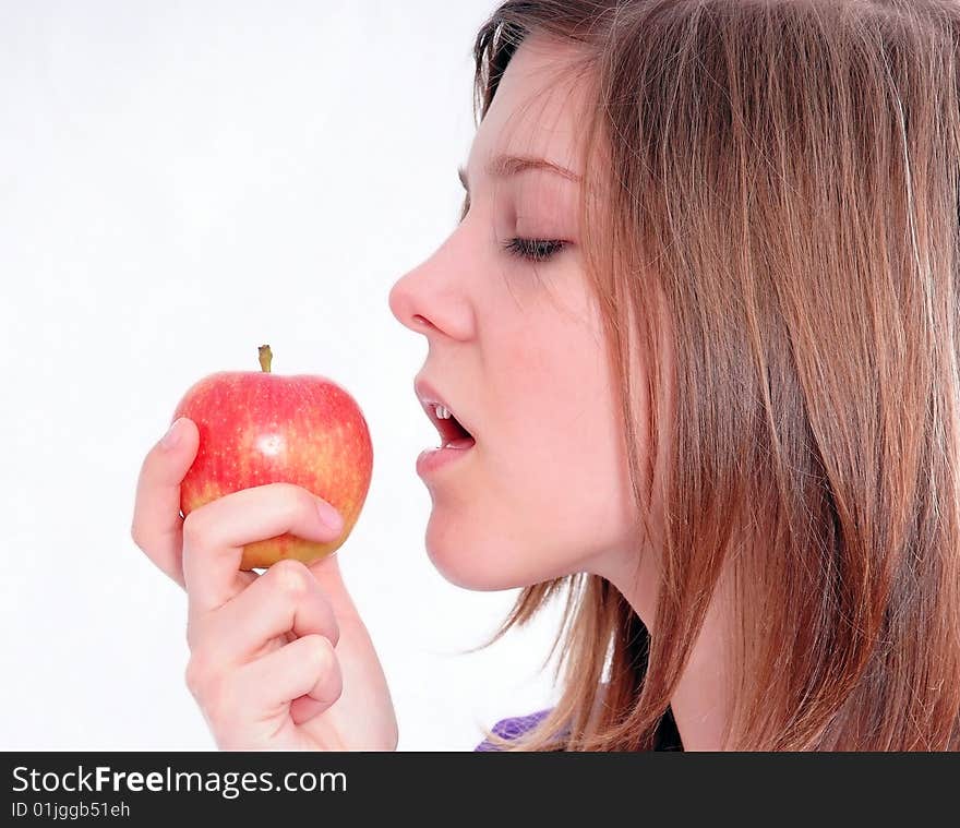 A studio shot of a beautiful girl holding an apple in her hand, isolated on white background. A studio shot of a beautiful girl holding an apple in her hand, isolated on white background