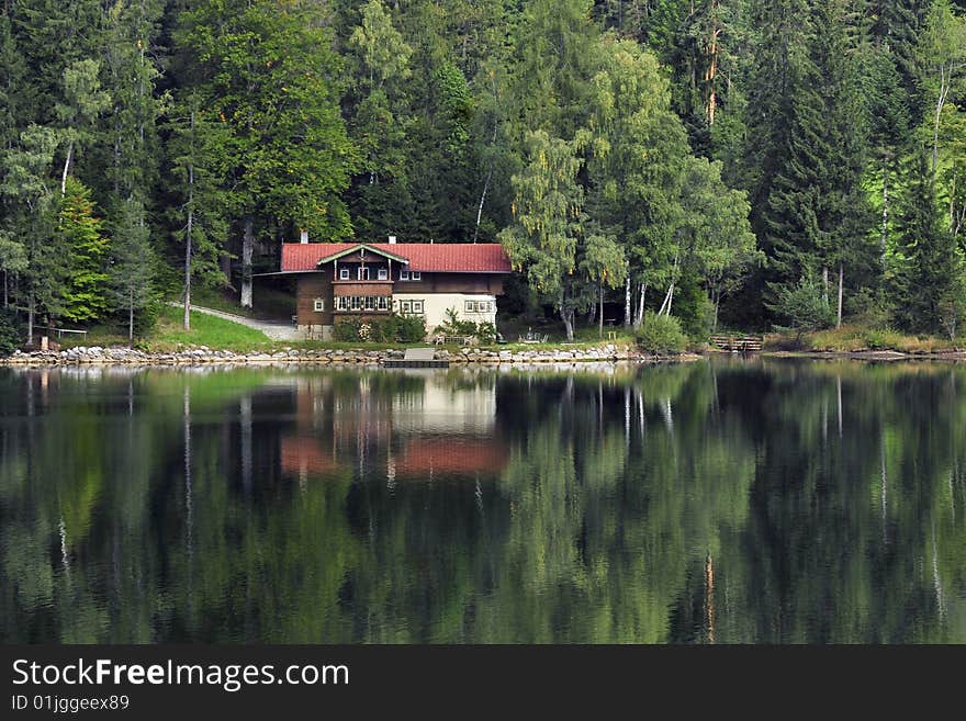 Home reflection in lake in wood